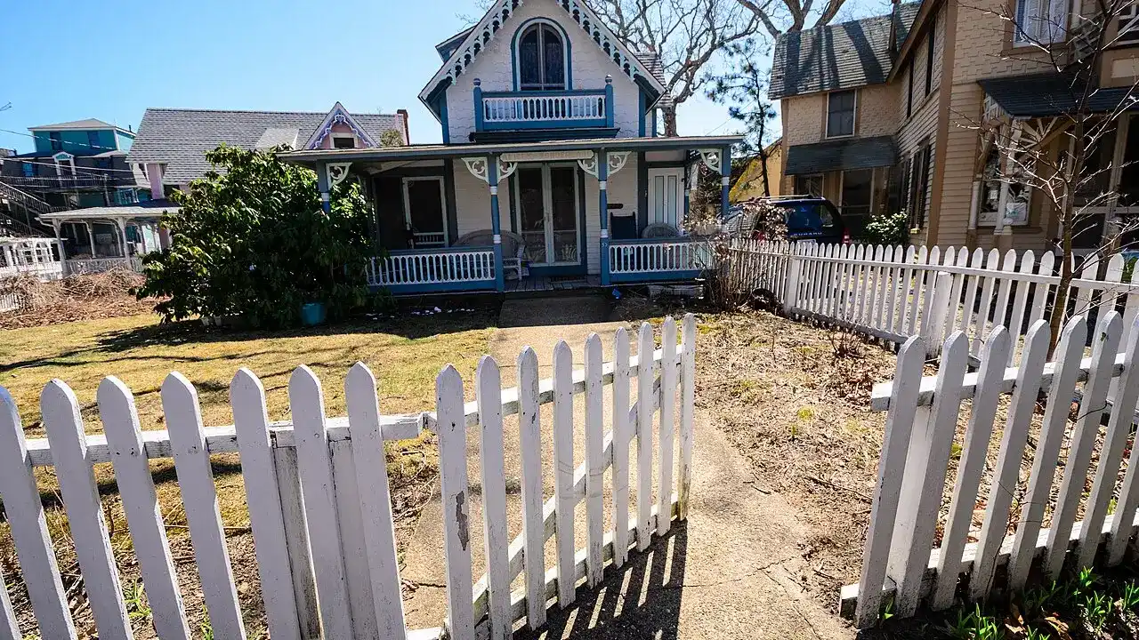 White picket fence and gate in front of a house