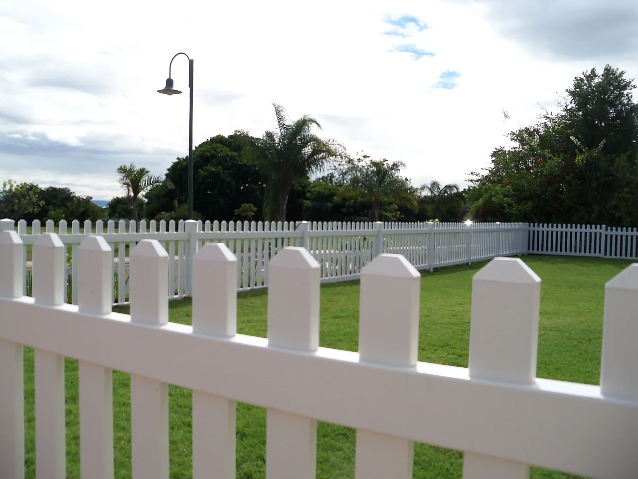 White vinyl picket fence with dog-ear caps