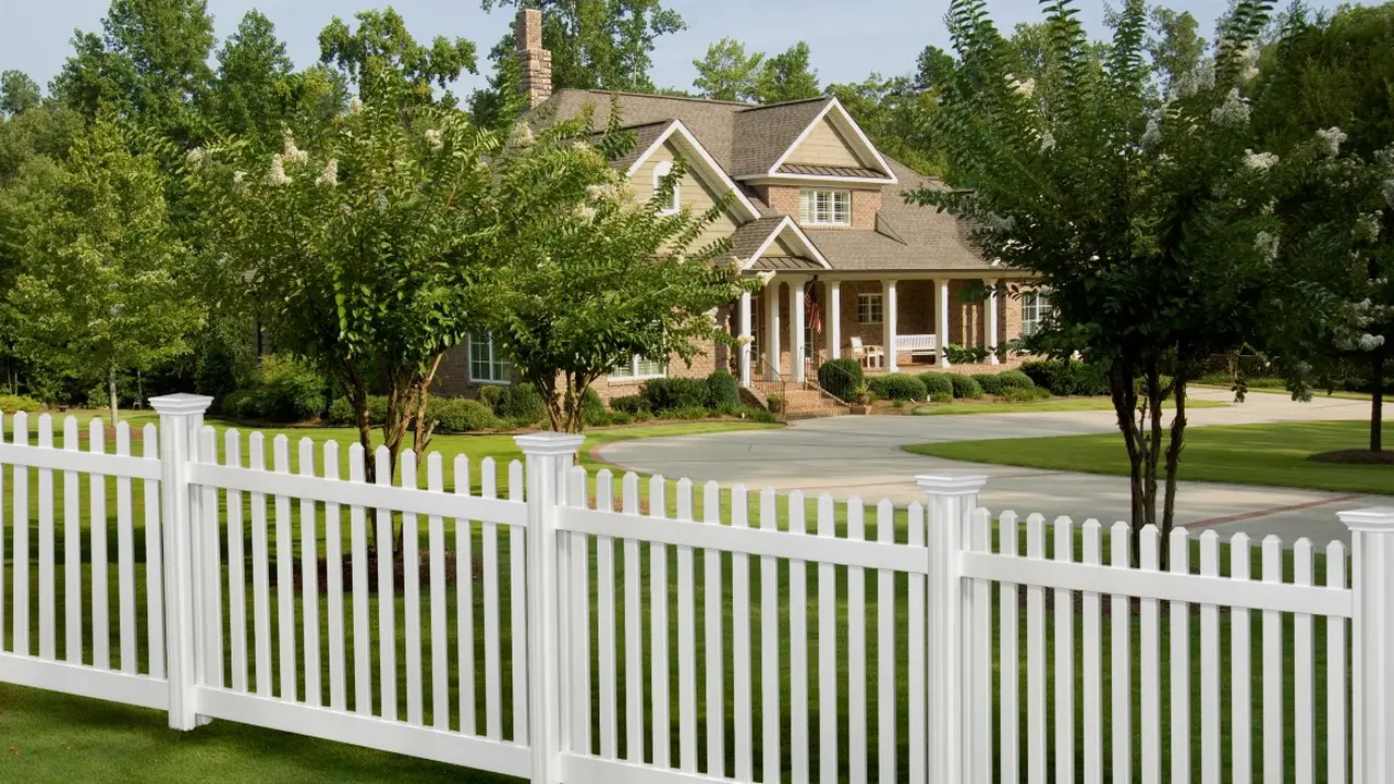 White vinyl picket fence in front of a house